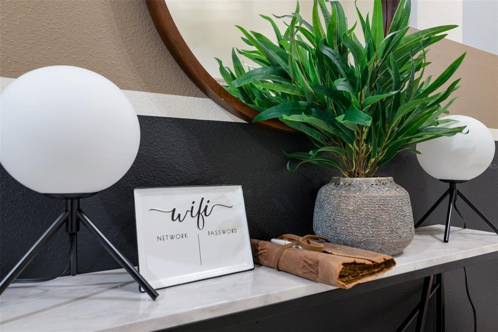 A console table features a WiFi sign, a potted plant, and two globe lamps — 3028 MAHALO DRIVE, DAVENPORT, FL