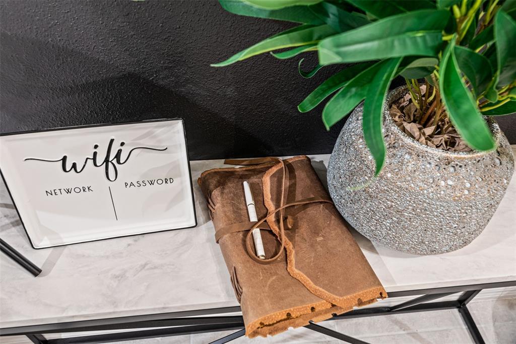 A white console table holds a WiFi sign, a leather-bound journal, and a potted plant — 3028 MAHALO DRIVE, DAVENPORT, FL