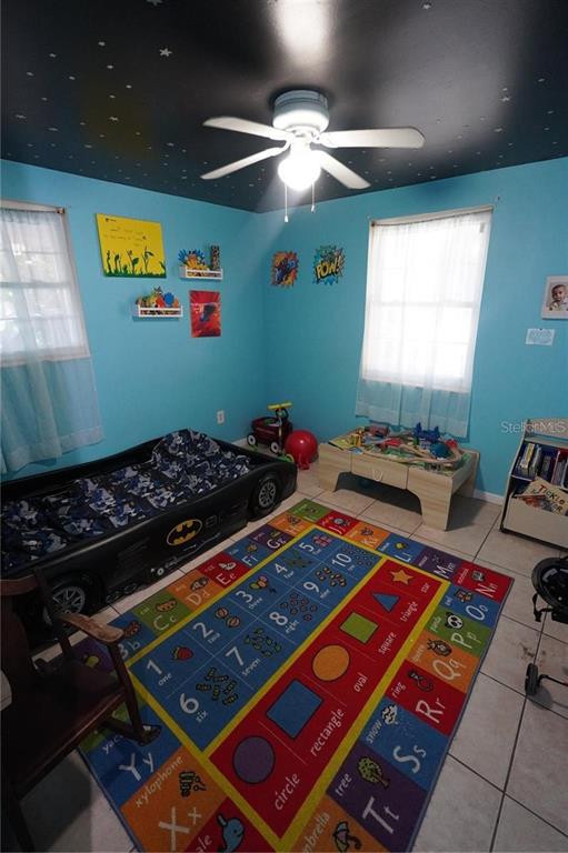 A child's bedroom features a car-shaped bed, a colorful educational rug, and a star-painted ceiling — 14611 SW 37TH COURT, OCALA, FL