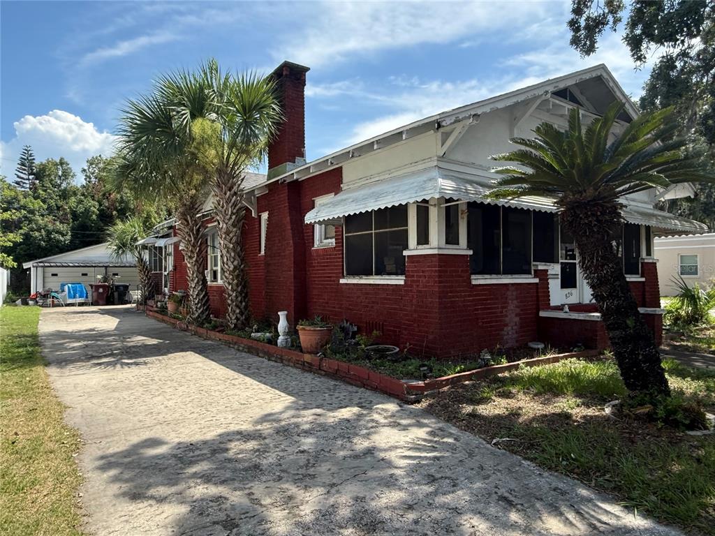 A red brick house with a screened porch and a concrete driveway under a blue sky — 826 W PRINCETON STREET, ORLANDO, FL
