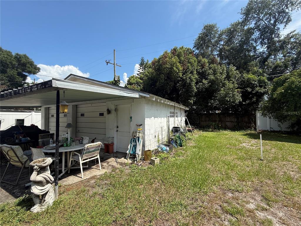 A white concrete block garage with a covered patio area and a grassy backyard — 826 W PRINCETON STREET, ORLANDO, FL