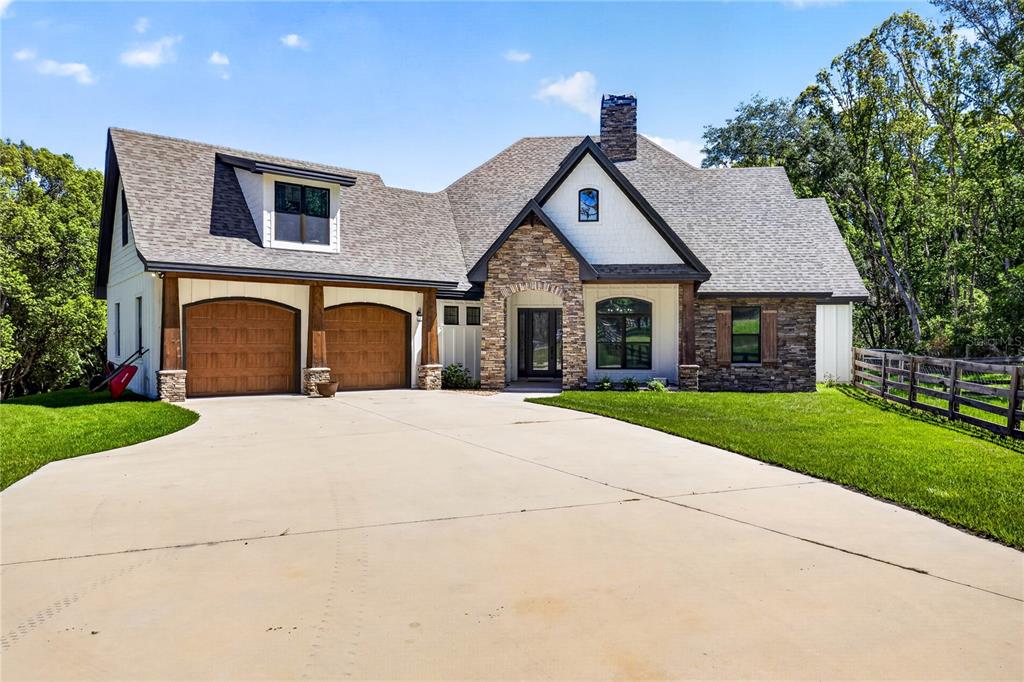 A two-story house with a stone facade, white siding, and a two-car garage — 17265 MEADOW BLUFF VIEW, DADE CITY, FL