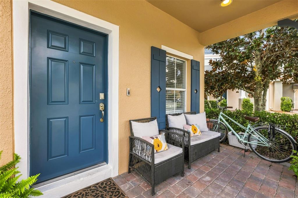 A blue front door and a small patio with two chairs and a bicycle — 16424 CEDAR CREST DRIVE, ORLANDO, FL