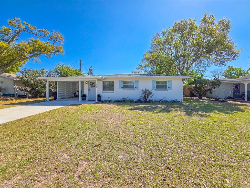 A single-story house with a white exterior, a carport, and a concrete driveway — 1807 GOLFVIEW BOULEVARD, SOUTH DAYTONA, FL