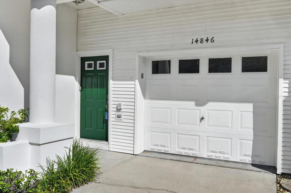 A screened-in porch overlooks a swimming pool, palm trees, and a multi-story apartment building — 14846 SEMINOLE TRAIL, SEMINOLE, FL