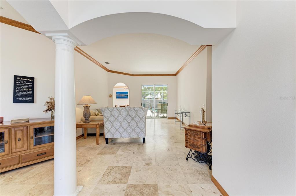 A living room with tile floors, a white column, and a view of a patio — 7604 52ND TERRACE E, BRADENTON, FL
