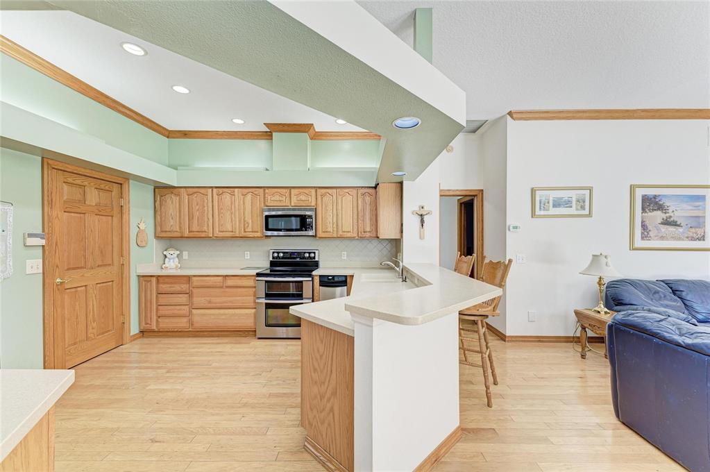 A kitchen with light wood cabinets, stainless steel appliances, and a peninsula counter — 7604 52ND TERRACE E, BRADENTON, FL
