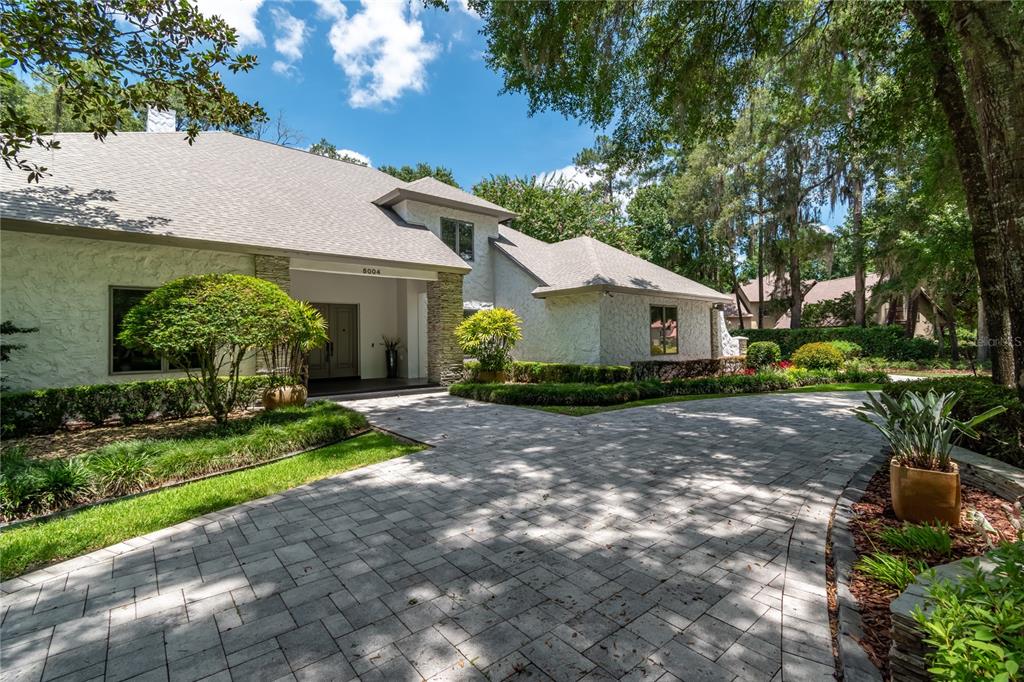 A white stucco house with a stone-accented entryway and a paved driveway — 5004 SE 5TH AVENUE, OCALA, FL