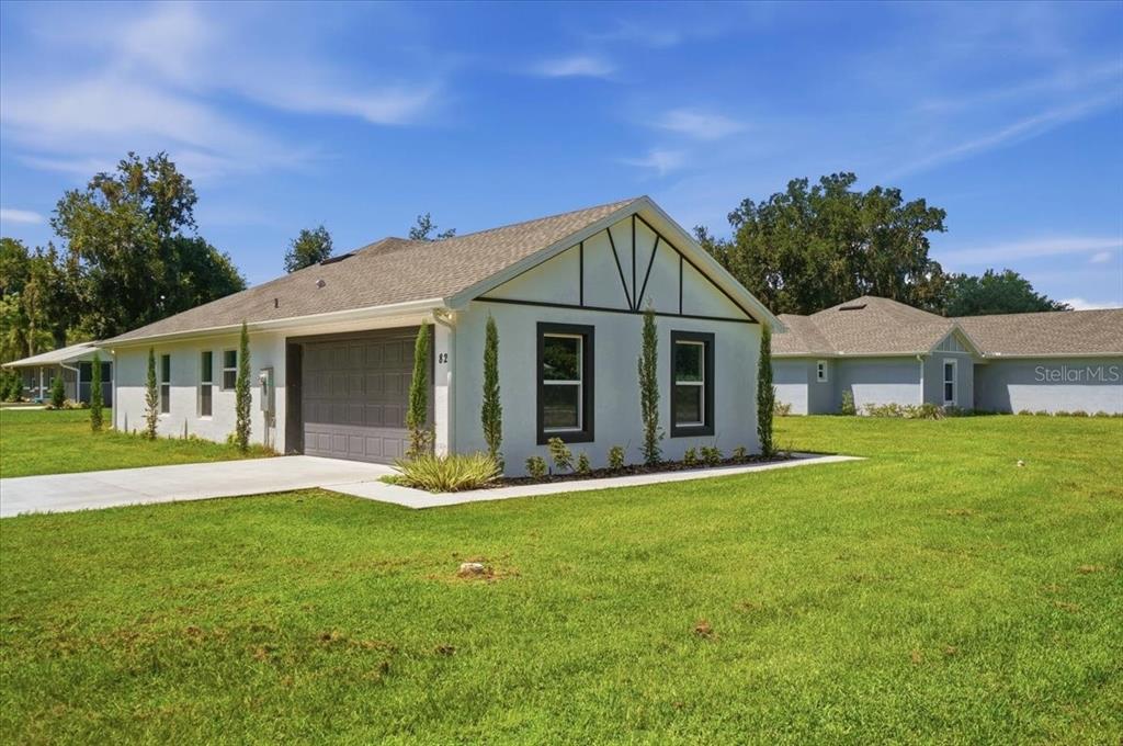 A single-story house with a white stucco exterior, dark trim, and an attached garage — 829 N CLERMONT AVENUE, FORT MEADE, FL