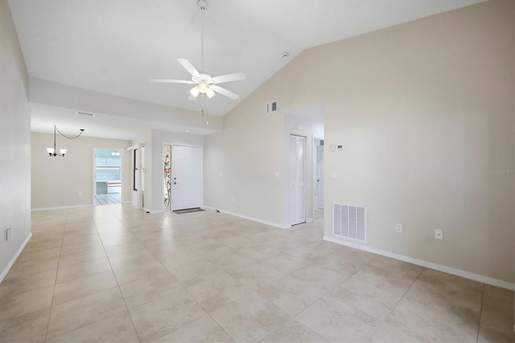 An open-concept living area features vaulted ceilings, a ceiling fan, and light-colored tile flooring — 214 SOUTHAMPTON DRIVE UNIT 327, VENICE, FL