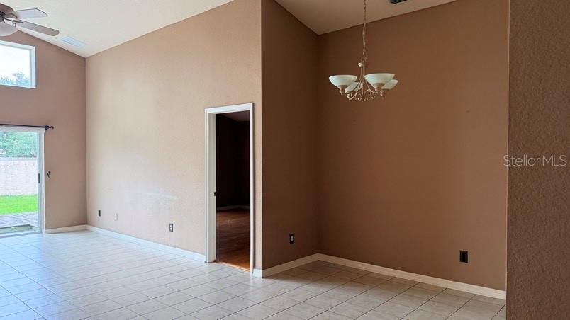 A room with tan walls, tile flooring, a chandelier, and a doorway leading to another room — 1120 VINETREE DRIVE, BRANDON, FL