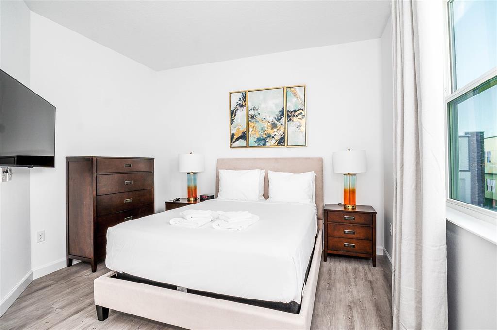A bedroom features a bed with a light-colored headboard, two nightstands, and a dark dresser — 277 FAMAGUSTA DRIVE, DAVENPORT, FL
