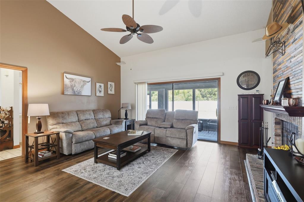 The rear exterior of a single-story house features a screened porch and a gray roof — 168 COMMUNITY DRIVE, DEBARY, FL