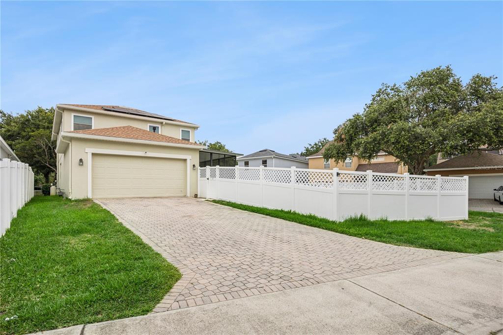 A two-story house with a paved driveway and a white vinyl fence — 14542 BLACK CHERRY TRAIL, WINTER GARDEN, FL