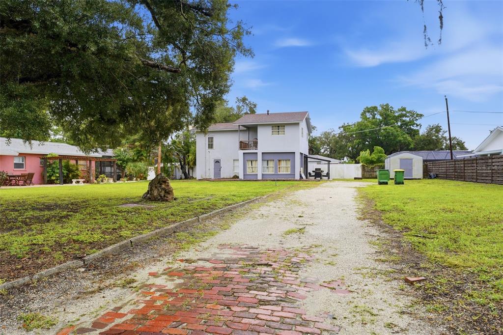 A two-story house with a brick and gravel driveway sits on a large grassy lot — 3052 ALTA VISTA ST, SARASOTA, FL