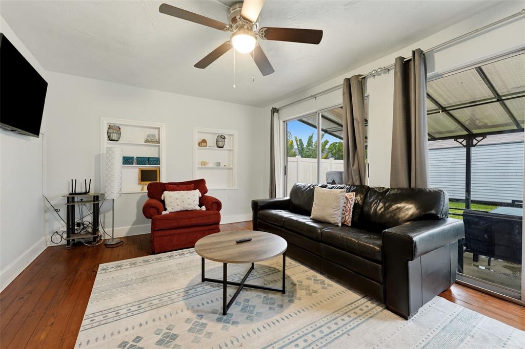 A living room features a black leather sofa, a red armchair, and a ceiling fan — 3052 ALTA VISTA ST, SARASOTA, FL
