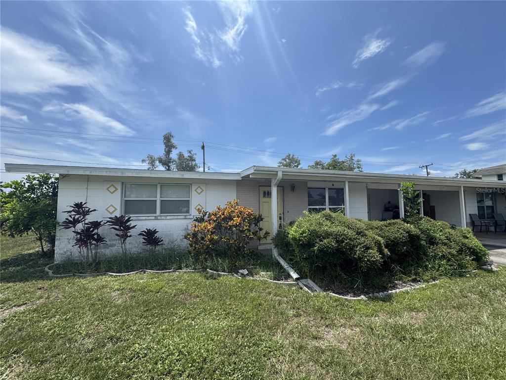 A single-story house with a white exterior, a yellow front door, and a covered porch — 376 BRIARWOOD ROAD, VENICE, FL