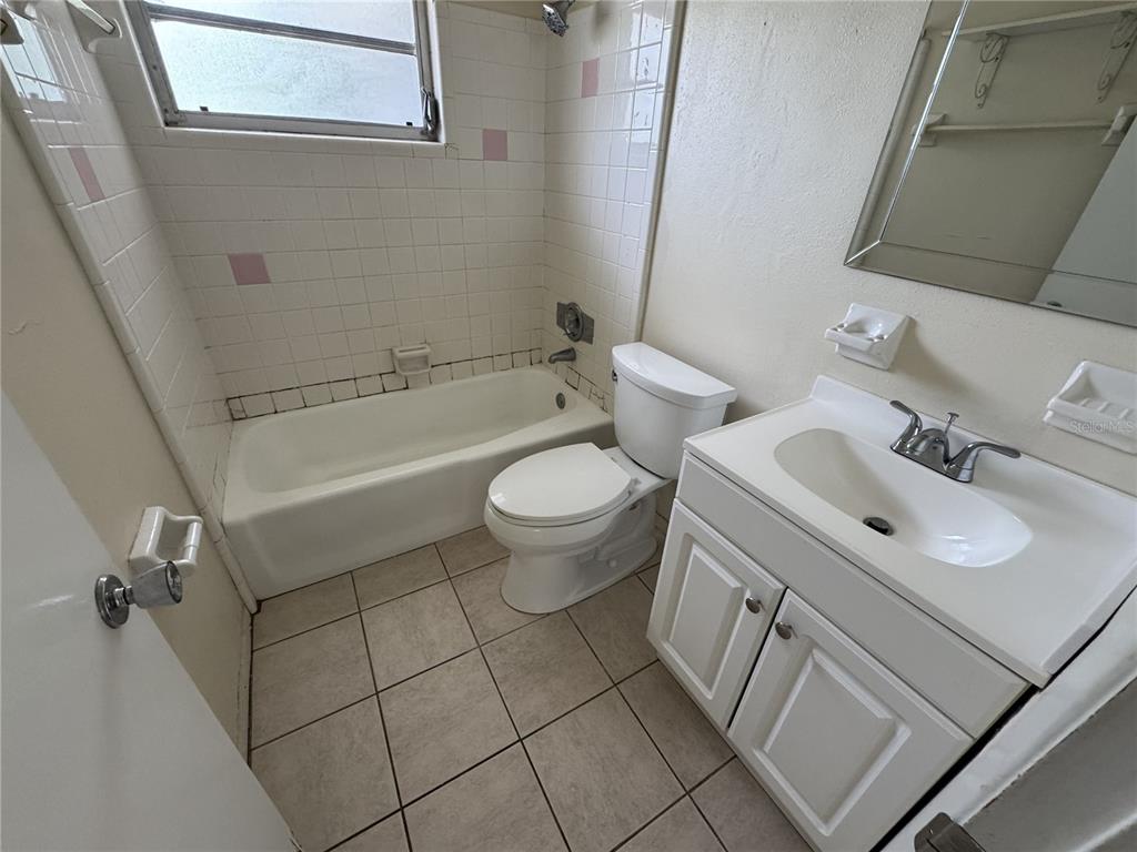 A bathroom features a white vanity, a toilet, and a tiled bathtub shower combination — 376 BRIARWOOD ROAD, VENICE, FL