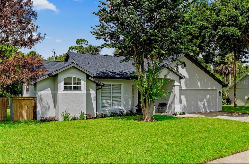 A single-story house with a gray roof, light-colored stucco exterior, and a two-car garage — 427 PENDREY DRIVE, PORT ORANGE, FL