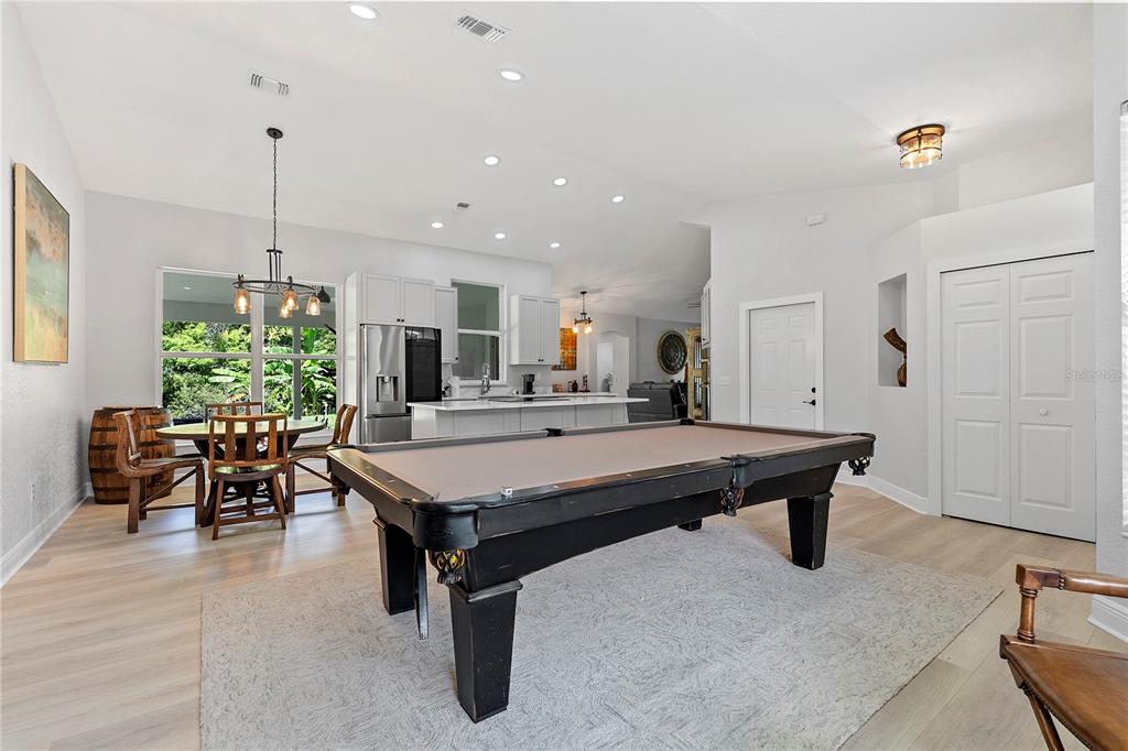 A spacious room features a pool table, a dining area, and an open-concept kitchen — 427 PENDREY DRIVE, PORT ORANGE, FL