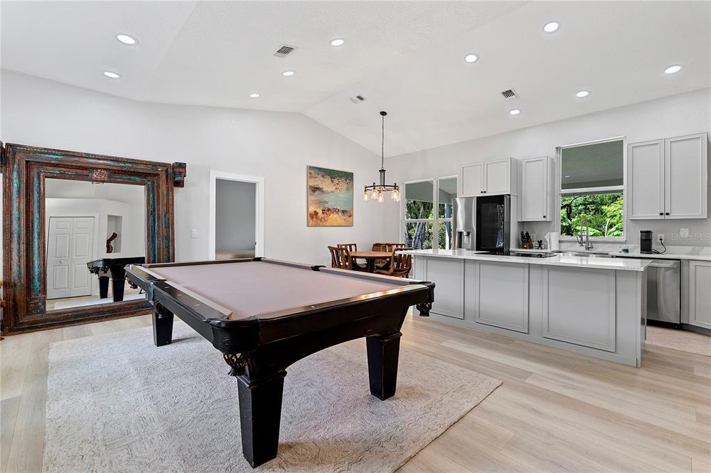 A room featuring a pool table, a kitchen with light cabinetry, and a large ornate mirror — 427 PENDREY DRIVE, PORT ORANGE, FL