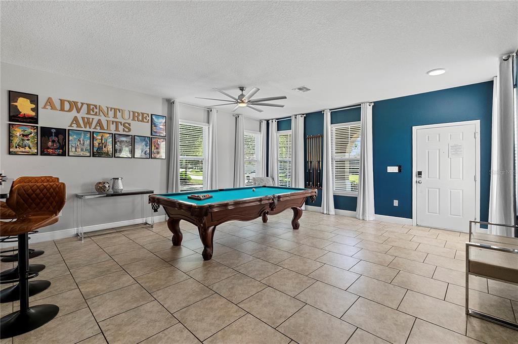 A game room features a pool table, tiled floors, and a blue accent wall — 4200 OAKTREE DRIVE, DAVENPORT, FL