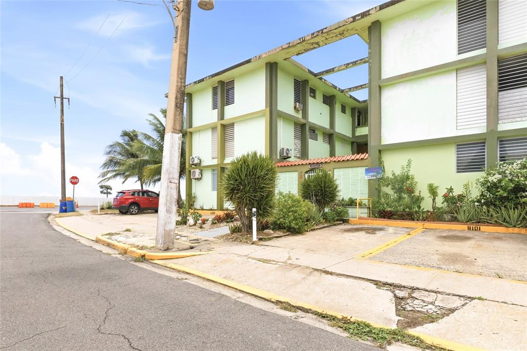 A three-story light green apartment building with parking spaces in the foreground — 10 CALLE COVALLE GANDIA STREET UNIT 201 B, ARECIBO, PR