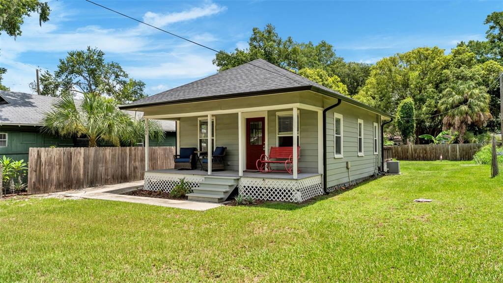 A small, light green house with a front porch, red door, and lattice skirting — 1034 S DAKOTA AVENUE, LAKELAND, FL