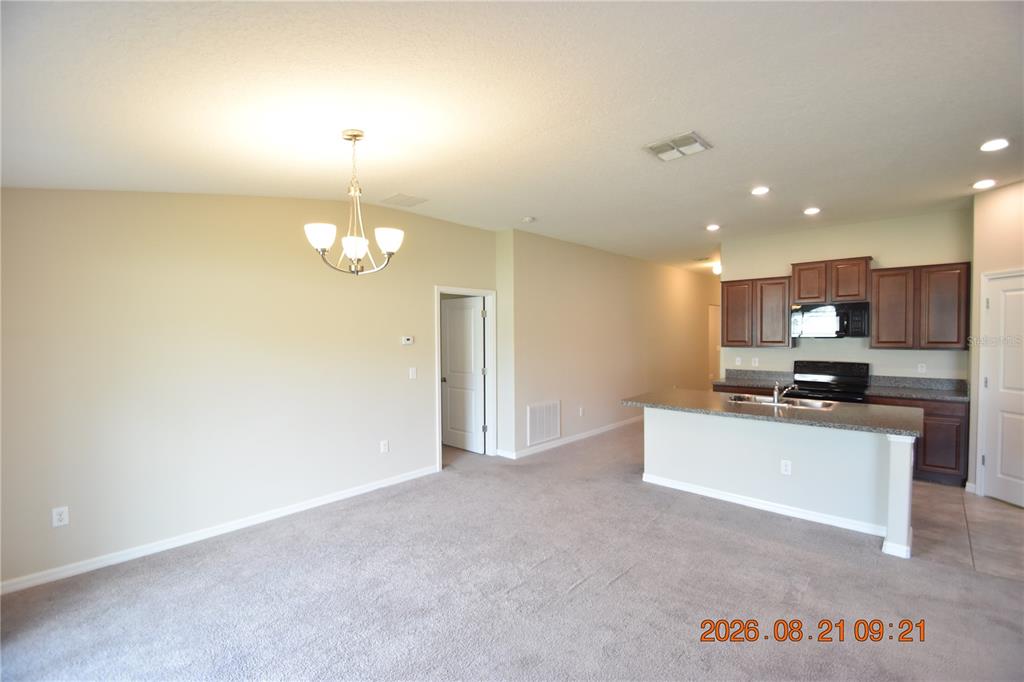 An open-concept living area features a kitchen with dark wood cabinets and a breakfast bar — 8436 HUNTERS FORK LOOP, RUSKIN, FL