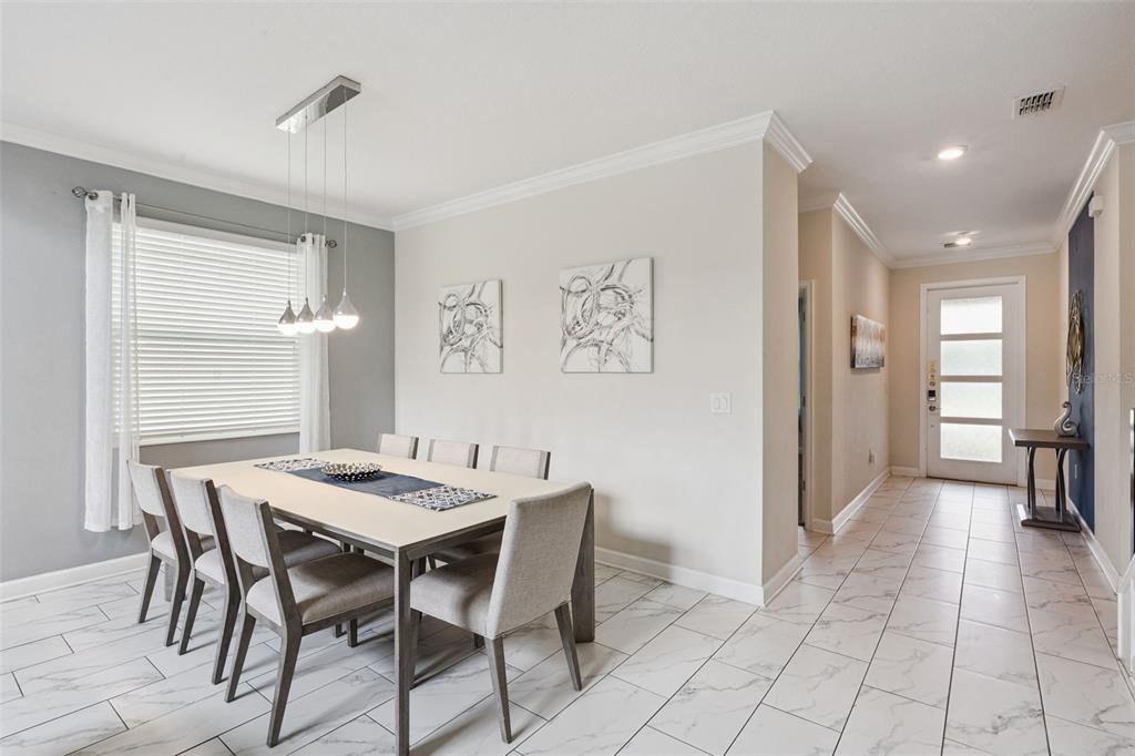 A dining room with a table, six chairs, and a pendant light on tiled floors — 682 WHISTLING STRAITS BOULEVARD, DAVENPORT, FL