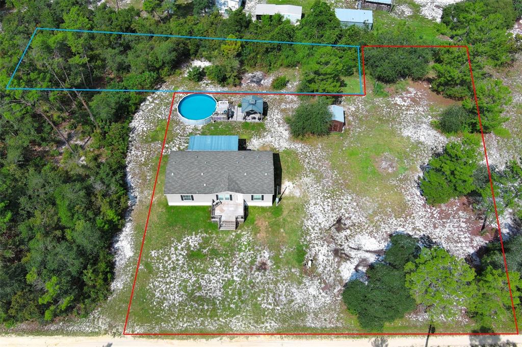 An aerial view shows a house with a pool and shed on a wooded lot — LAKE LULU DRIVE, PAISLEY, FL