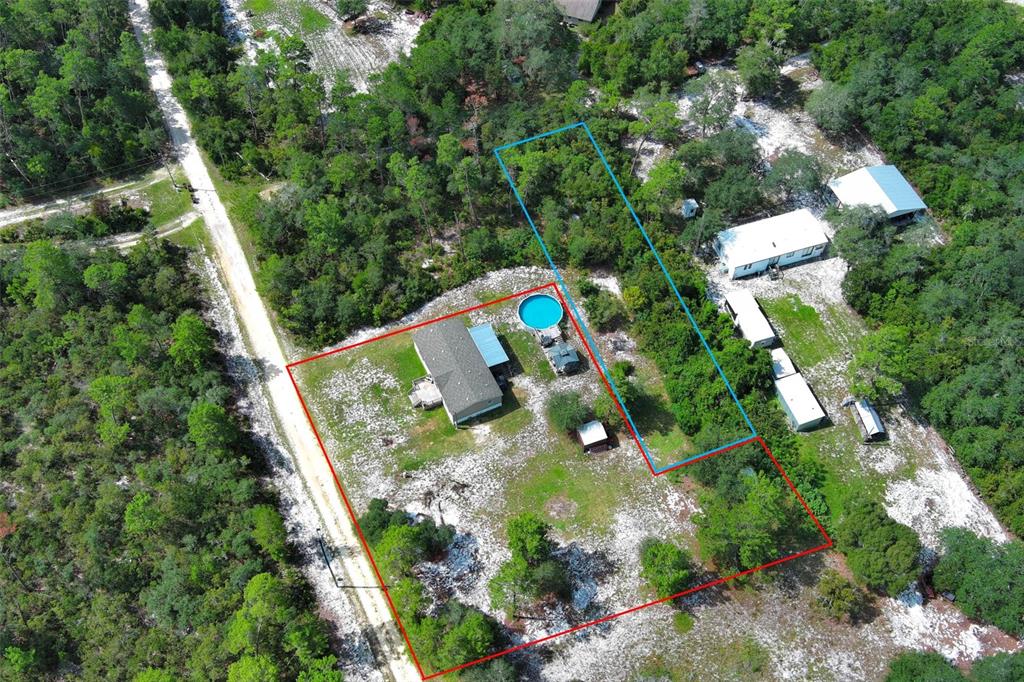 An aerial view shows a house with a pool and outbuildings on a wooded lot — LAKE LULU DRIVE, PAISLEY, FL