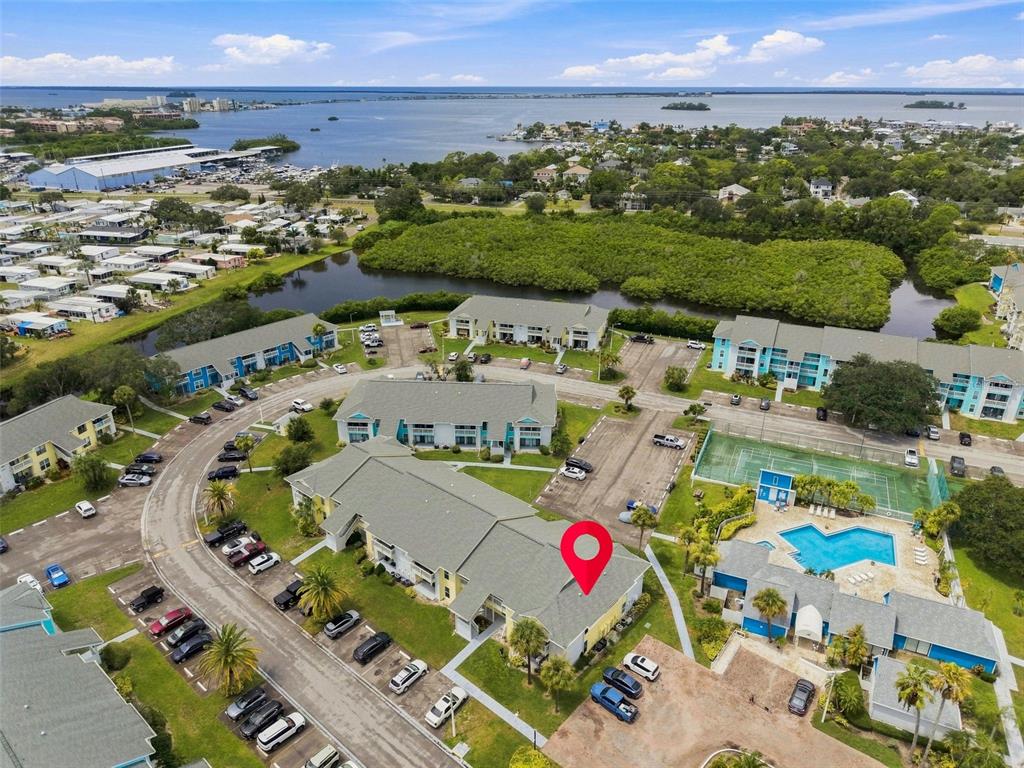 A two-story yellow apartment building with balconies and palm trees at dusk — 455 ALT 19 S UNIT 17, PALM HARBOR, FL