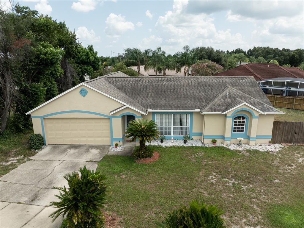 An aerial view of a single-story tan house with a two-car garage and shingled roof — 832 WHITE BIRCH COURT, ORANGE CITY, FL