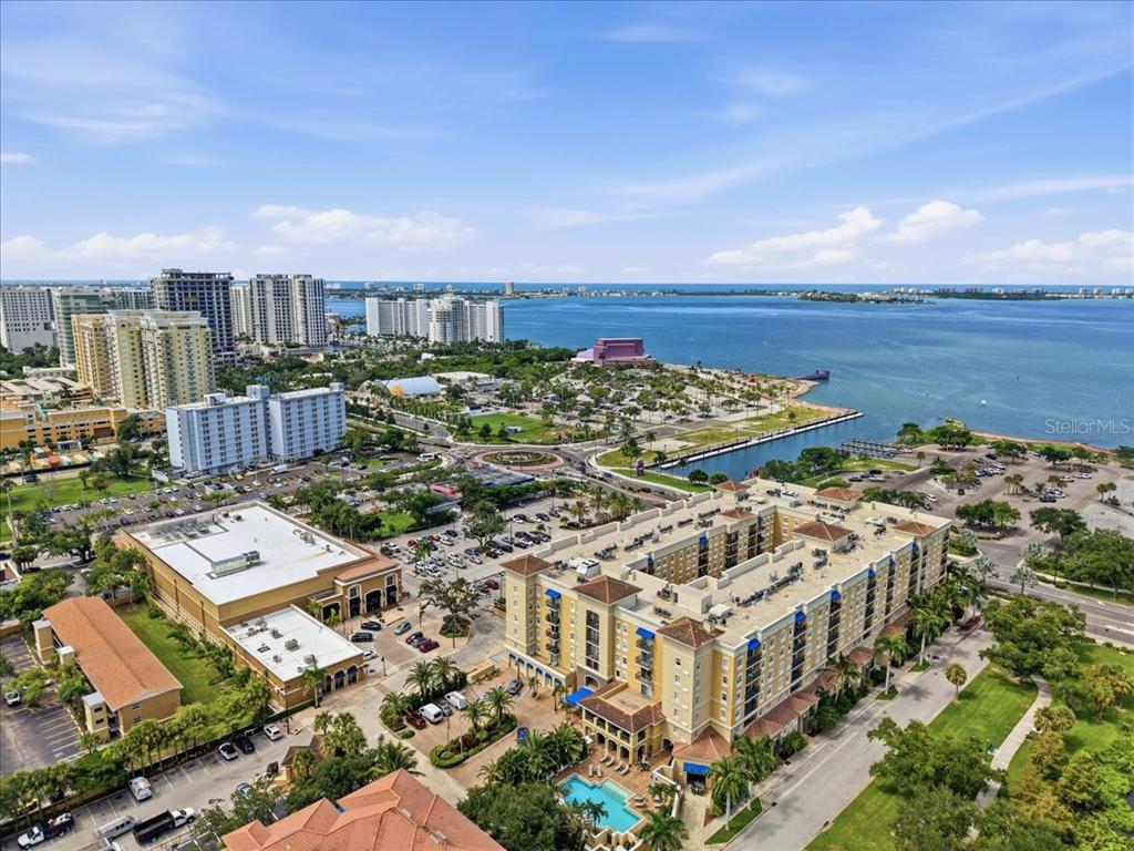 An aerial view of a coastal city featuring multi-story buildings, parking lots, and a waterfront area — 1064 N TAMIAMI TRAIL UNIT 1206, SARASOTA, FL