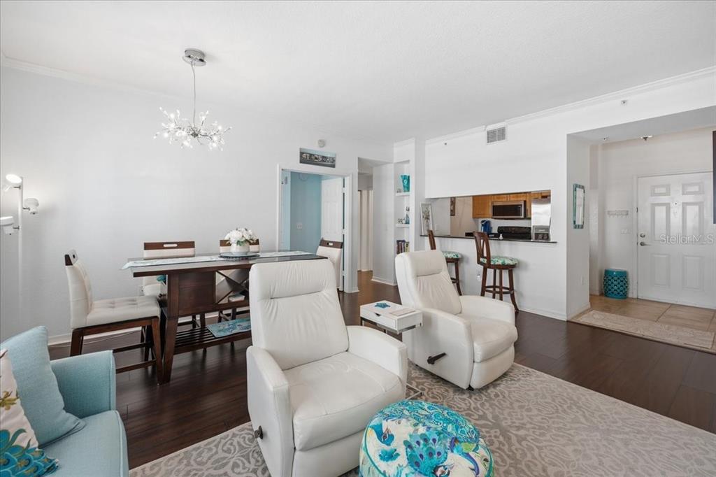 A living and dining area features white walls, dark wood floors, and two white recliners — 1064 N TAMIAMI TRAIL UNIT 1206, SARASOTA, FL