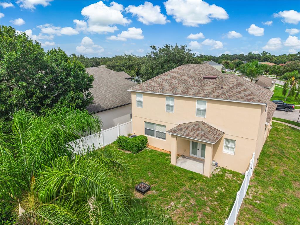 An aerial view of a two-story house with a backyard, patio, and white vinyl fencing — 3906 QUARTZ AVENUE, ORLANDO, FL