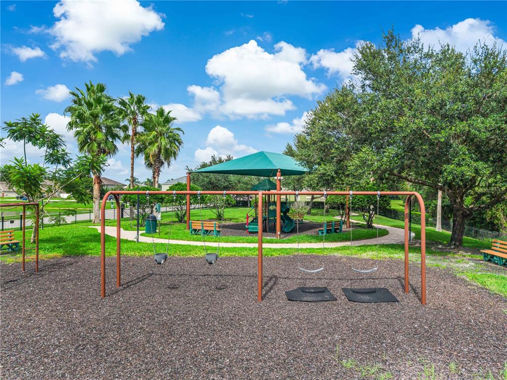 A playground with a swing set, a shaded play structure, and palm trees on a sunny day — 3906 QUARTZ AVENUE, ORLANDO, FL
