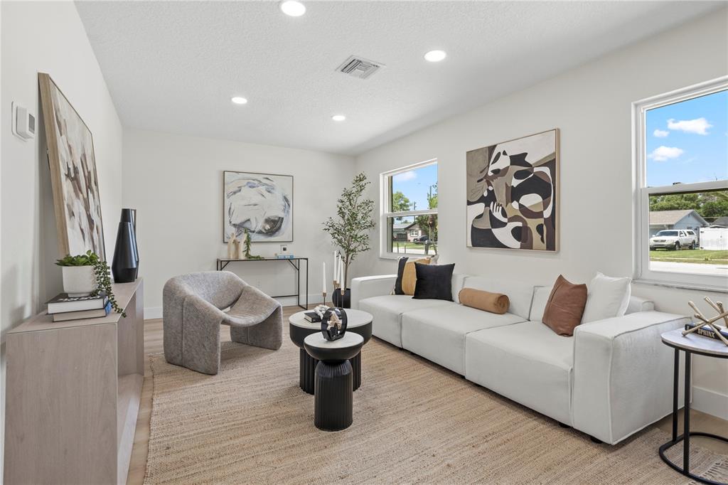 A living room features a white sofa, a grey armchair, and a jute area rug — 530 GEORGIA AVENUE, LONGWOOD, FL