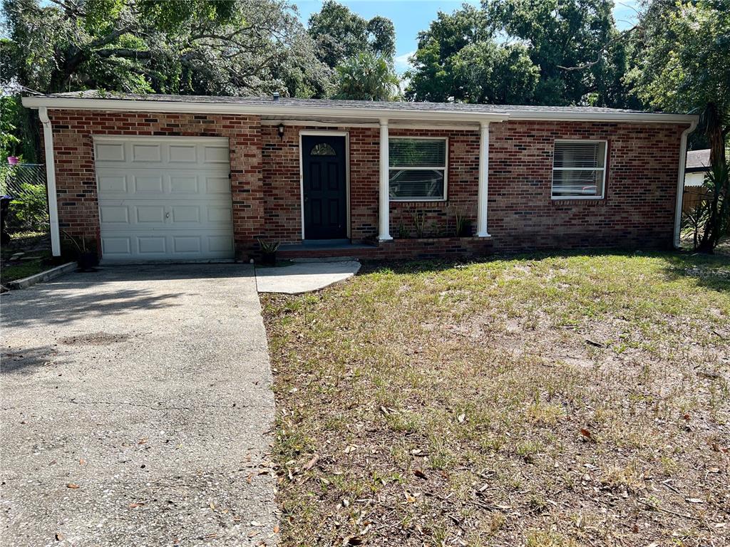 A single-story brick house features a garage, a front entrance, and a concrete driveway — 1011 SANTA BARBARA ROAD, ORLANDO, FL