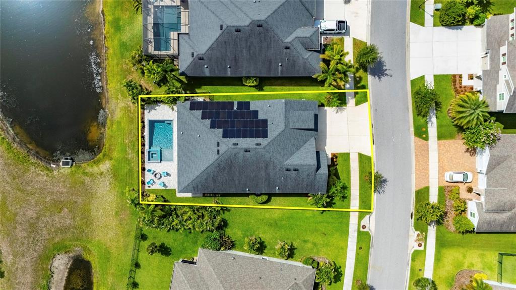 An aerial view shows a house with a solar panel array and a backyard pool — 7322 PARADISO DRIVE, APOLLO BEACH, FL