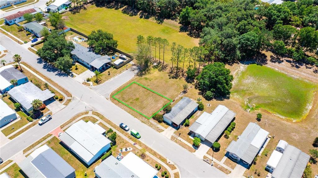An aerial view shows a vacant residential lot outlined in green within a suburban neighborhood — CHRIS DR., WESLEY CHAPEL, FL