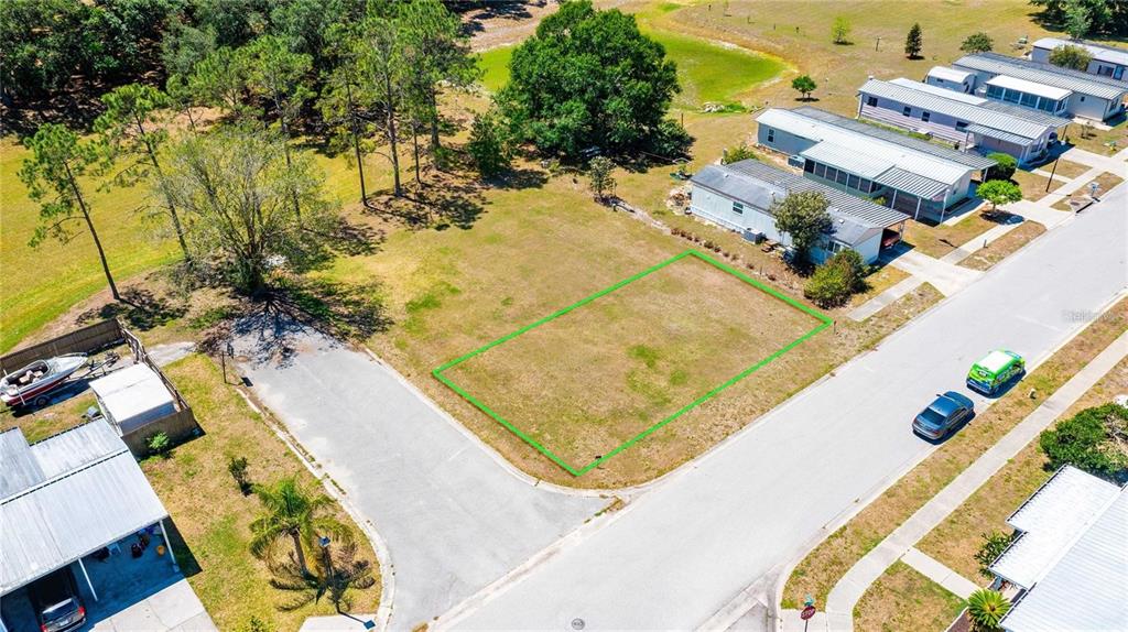 An aerial view shows a vacant rectangular lot outlined in green within a residential neighborhood — CHRIS DR., WESLEY CHAPEL, FL