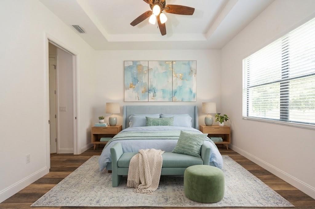 A bedroom features a blue upholstered bed, a matching bench, and a tray ceiling — 59 GREEN CIRCLE, PALM COAST, FL
