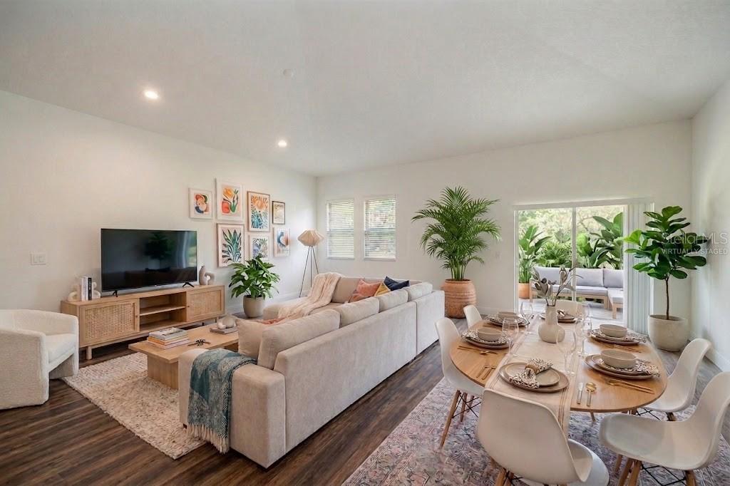 A living and dining area with light-colored furniture, wood flooring, and a sliding glass door — 59 GREEN CIRCLE, PALM COAST, FL