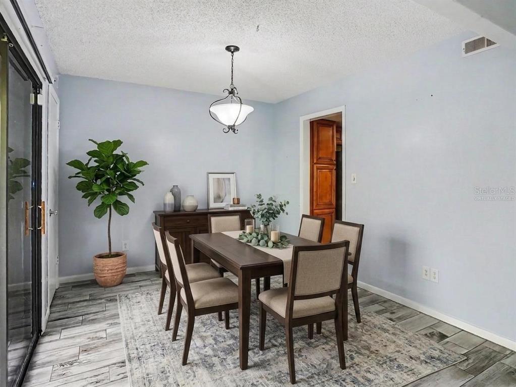 A bedroom features a bed with blue pillows, a ceiling fan, and a sliding glass door — 4828 PEBBLE BEACH DRIVE UNIT A1108, ORLANDO, FL