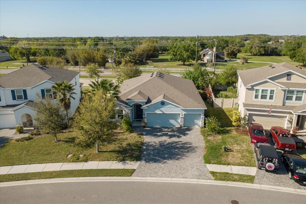 An aerial view shows a light blue single-story house with a paved driveway and garage — 6702 DEVESTA LOOP, PALMETTO, FL