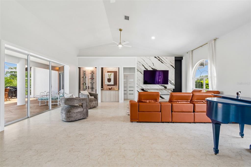 A living room features a marble fireplace, orange leather sofa, and a blue grand piano — 3339 DESOTO DRIVE, PUNTA GORDA, FL
