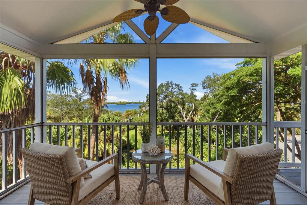 A view of a lush green landscape with palm trees overlooking a body of water — 8963 FISHERMENS BAY DRIVE, SARASOTA, FL