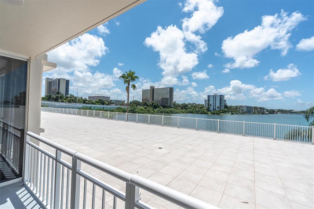 A tall, multi-story residential building with balconies and palm trees under a clear sky — 100 PIERCE STREET UNIT 305, CLEARWATER, FL